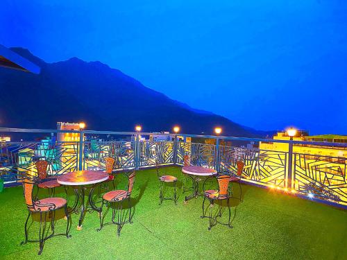 a patio with tables and chairs on a balcony at LA Riqueza Pride Inn # Rootop Swimming Pool with Mountain View # Free Parking # Tapovan # Center of Rishikesh# in Rishīkesh
