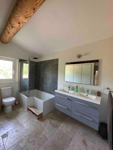 une salle de bain avec deux lavabos et une baignoire et des toilettes dans l'établissement Mas Paradou, au coeur des Alpilles, à Paradou