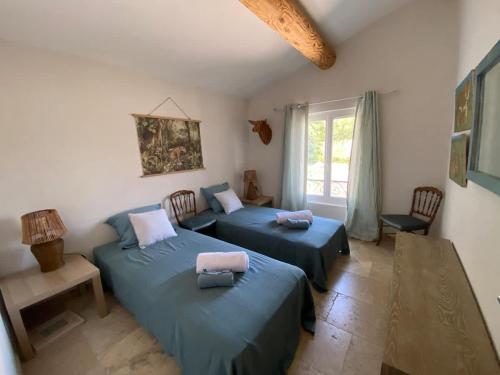 a bedroom with two beds and a window at Mas Paradou, au coeur des Alpilles in Paradou