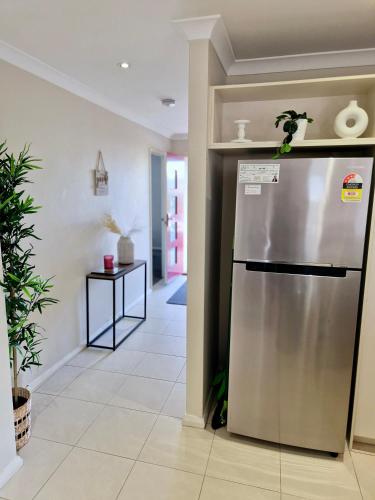 a kitchen with a stainless steel refrigerator in a hallway at Your comfortable getaway home in Clarkson