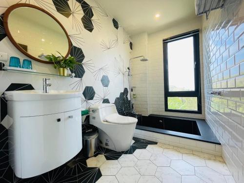 a bathroom with a toilet and a sink and a mirror at Piano Hotel in Xiaoliuqiu