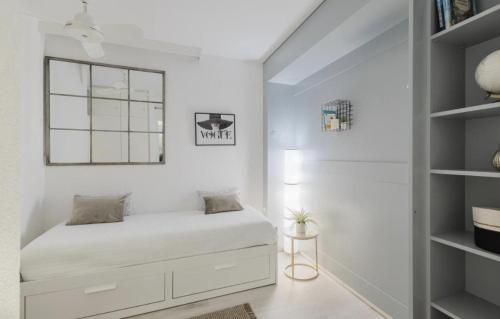 a white bedroom with a bed and shelves at The Lac View in Bissone
