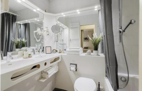 a white bathroom with a sink and a shower at The Lac View in Bissone