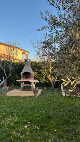 a small brick oven in a yard with trees at Apartment Petar in Begi in Vrsar