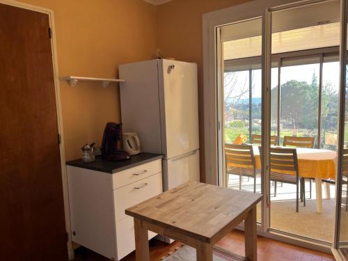 Il comprend une cuisine équipée d'un réfrigérateur et d'une table. dans l'établissement Maison au pied du Mont Ventoux, à Bédoin