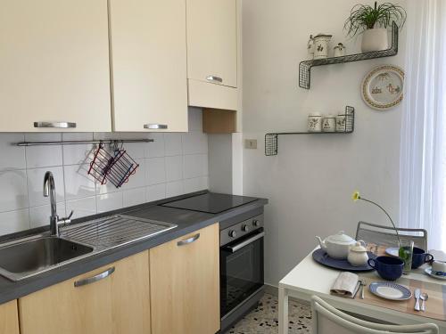 a small kitchen with a sink and a stove at Dove il tramonto incontra il mare, attico panoramico a due passi dalla spiaggia in Minturno