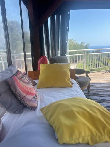- une chambre avec un lit doté d'oreillers jaunes et un balcon dans l'établissement Casa Di Mammò, à Cervione