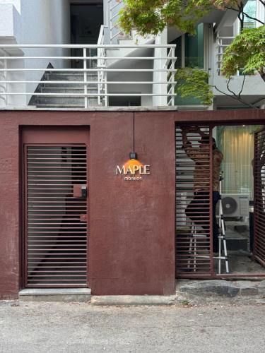 a person standing in a doorway of a building at MAPLE MANSION Hongdae in Seoul