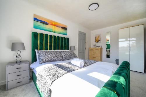 a bedroom with a white bed with a green headboard at 51VL For your Stylish and Relaxed Stay with Free Parking and Free WiFi in Kirkstall