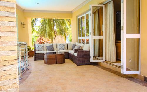 a living room with a couch on a patio at Tamasha Luxury Villa - Diani in Diani Beach