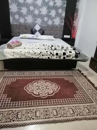 a bedroom with a bed with a rug on the floor at Ashta Lakshmi Tourist Home Stay in Indore