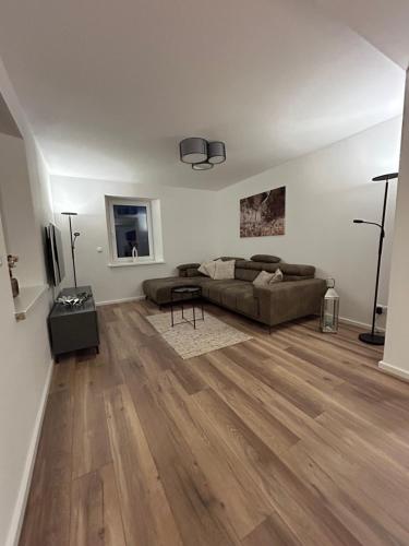 a living room with a couch and wooden floors at Mohla-Suite in Köditz