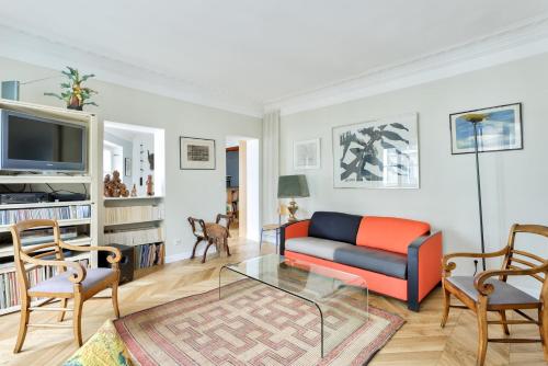 un salon avec un canapé et une télévision dans l'établissement Chic Retreat, Central Marais, à Paris