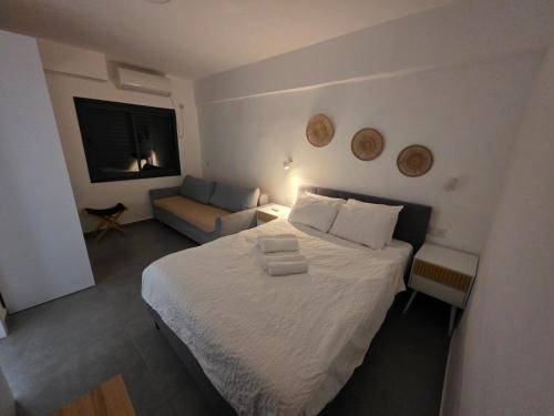 a small bedroom with a bed and a couch at Benemanuel Oasis in Beer Sheva