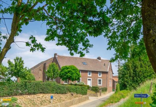 a large brick house with a road at B&B Haspenhoeve in Tongeren