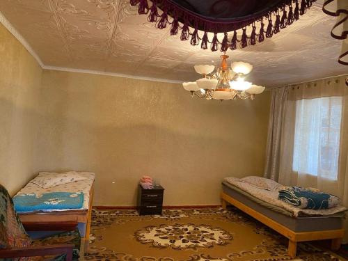 a bedroom with two beds and a chandelier at "Martin" guest house in Kara-Talaa