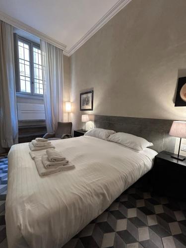 ein Schlafzimmer mit einem großen weißen Bett mit Handtüchern darauf in der Unterkunft Palazzo Mormorai in Florenz