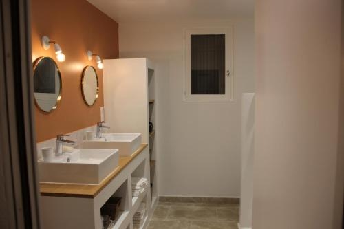 une salle de bain avec deux lavabos et deux miroirs dans l'établissement Villa Stéphanie, à Saint-Martin-de-la-Brasque