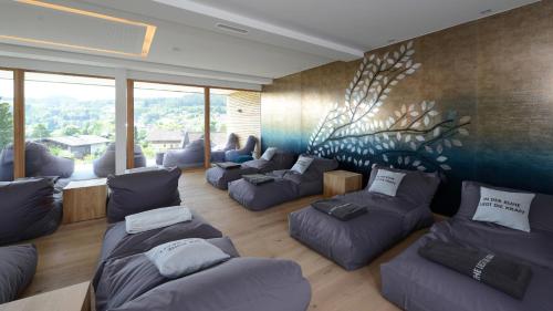 a living room with couches and a painting on the wall at Hotel Moserhof in Seeboden