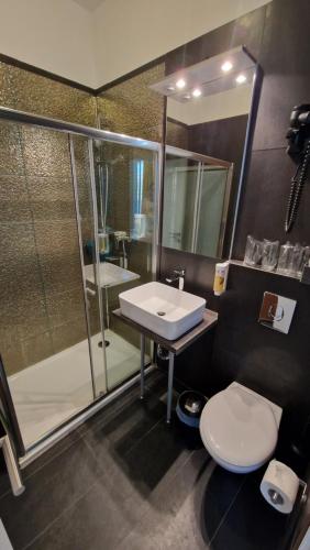 a bathroom with a sink and a shower and a toilet at Hotel Plaza in Pag