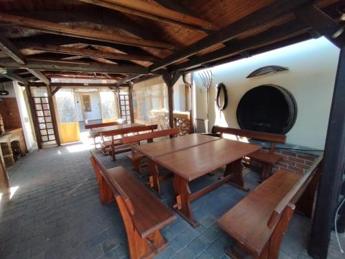 a room with wooden tables and benches and a wine cellar at Vinařský dvůr Valtice in Valtice