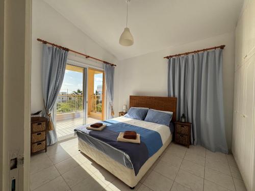 a bedroom with a bed and a large window at New cozy Villa near the beaches in the Magnificent Gardens of Regina with swimming pools! in Paphos City