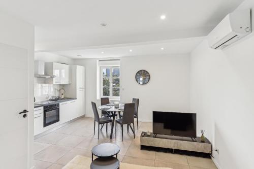 une cuisine et une salle à manger avec une table et une télévision dans l'établissement Appartement de caractère Central Cosy & Calme, à Pierre-Bénite