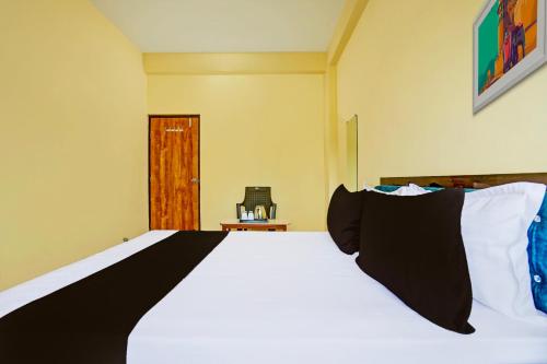 a bedroom with a bed with black and white pillows at Hotel O Zoo Palace in Nagpur