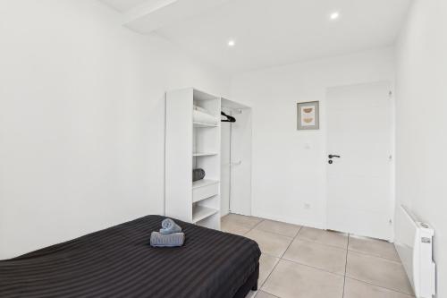 - une chambre avec un lit et des murs blancs dans l'établissement Appartement de caractère Central Cosy & Calme, à Pierre-Bénite