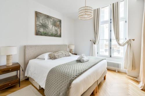 une chambre blanche avec un lit et une fenêtre dans l'établissement GuestReady - Sunny Retreat with Tower Views, à Bordeaux