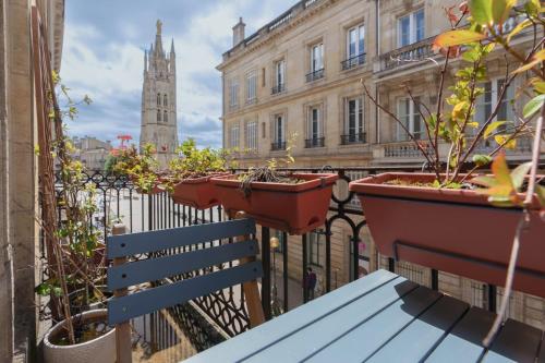 un balcon avec un banc et des plantes en pot sur une clôture dans l'établissement GuestReady - Sunny Retreat with Tower Views, à Bordeaux