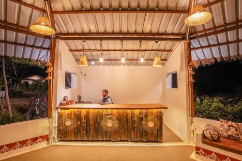 a man is standing at a bar in a garage at WOW STAYZ2 Pachmarhi Foothill Cottages in Pachmarhī