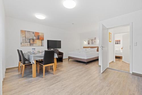 a living room with a dining table and a bed at Apartments Münchbach - near Europa-Park and Rulantica in Rust