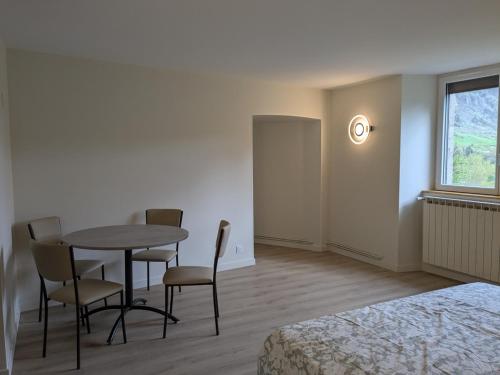 une pièce avec une table, des chaises et une fenêtre dans l'établissement Au bord du Tarn, à Vabre