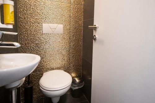 a bathroom with a toilet and a sink at Hotel Plaza in Pag