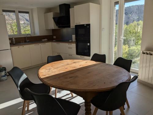 une cuisine avec une table en bois et quelques chaises dans l'établissement Au bord du Tarn, à Vabre