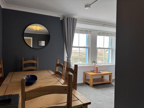 a dining room with a table and a mirror at Bayview in Anstruther