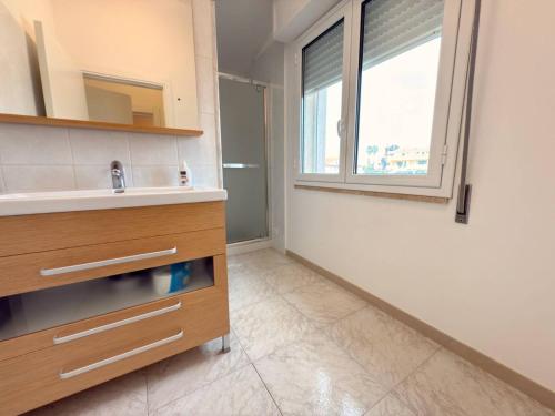 a bathroom with a sink and a window at iDream on the sea in Punta Braccetto