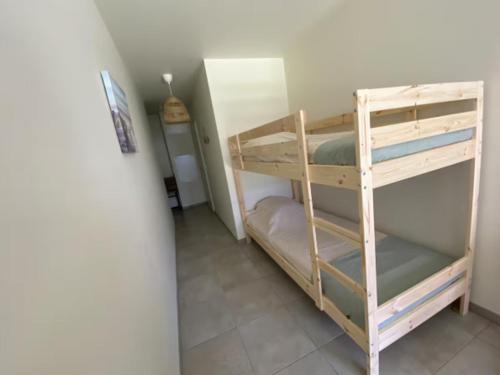 Cette chambre comprend 2 lits superposés et un couloir. dans l'établissement Appartement Remember à 700m de l'Océan, à Mimizan-Plage