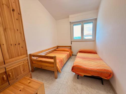 a bedroom with two beds and a window at iDream on the sea in Punta Braccetto