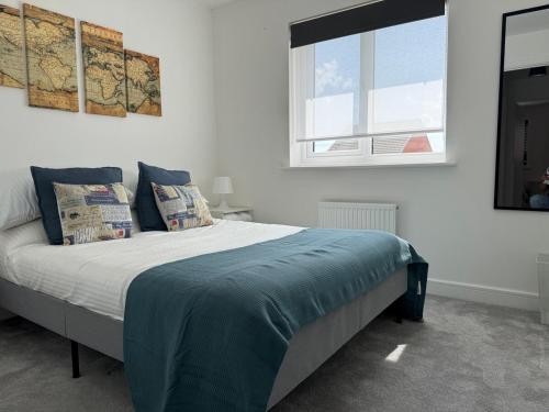 une chambre avec un lit avec des oreillers et une fenêtre dans l'établissement Strikingly Stylish Exeter Retreat - Modern 3-Bed, à Exeter