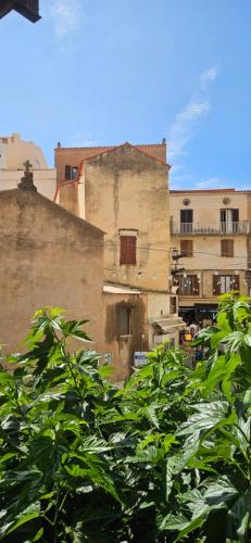un groupe de bâtiments avec des arbres au premier plan dans l'établissement Le Royal Hôtel Restaurant, à Bonifacio