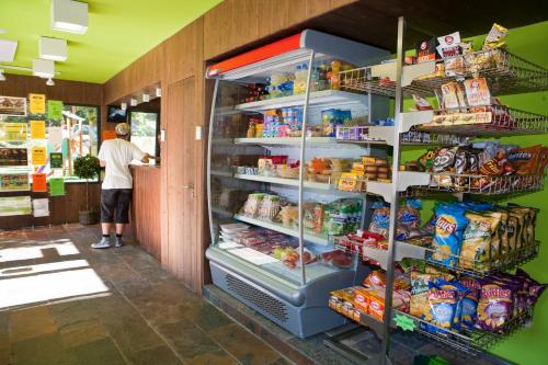 a man standing in a refrigerator in a store at Bungalows Verneda Mountain Resort in Arrós