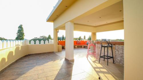a patio with a fence and a table and chairs at Tamasha Luxury Villa - Diani in Diani Beach
