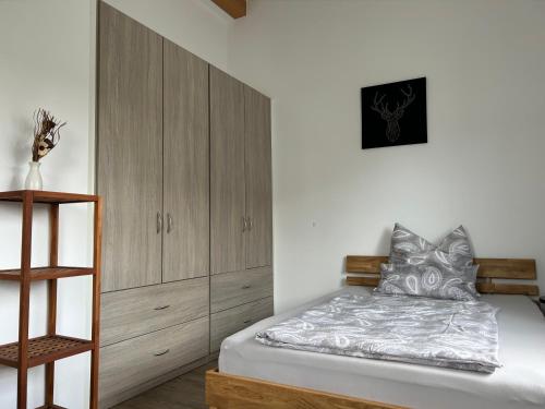 a bedroom with a bed and a wooden cabinet at Boardinghouse Gruber in Kranzberg
