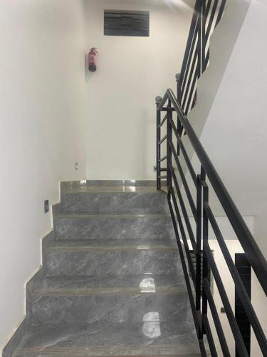 a staircase with a metal railing next to a wall at Chambre meublée avec balcon 3S Ngor Almadies Dakar in Dakan