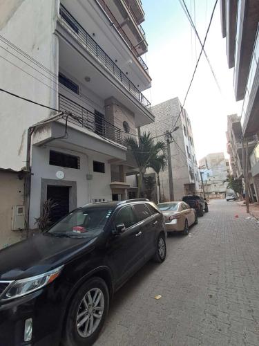 a black car parked on a street next to a building at Chambre meublée avec balcon 3S Ngor Almadies Dakar in Dakan
