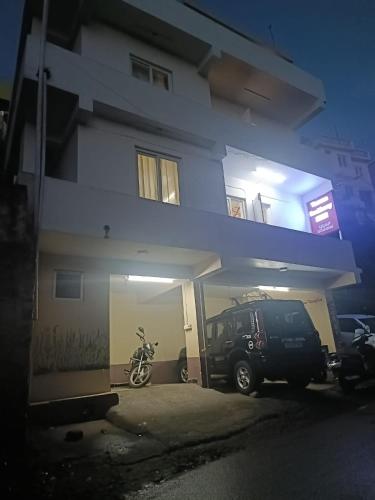 a car parked in a garage next to a building at Yamuna Residency by HRS Stays in Ooty
