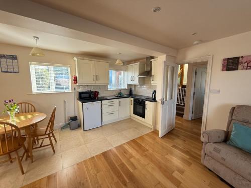 a kitchen and living room with a table and a couch at Mariner's Rest - Cahersiveen in Cahersiveen