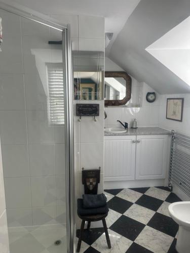a bathroom with a glass shower and a chair at Tallow House in Ludlow